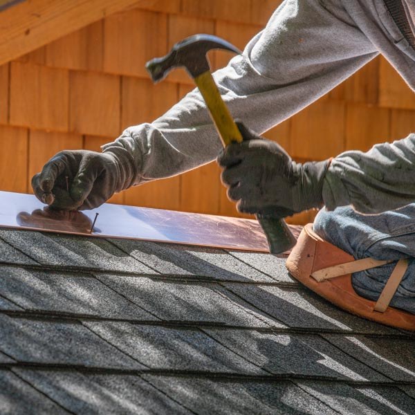 A man installs shingles on a roof promoting roof repair services in Santa Cruz & Monterey Counties