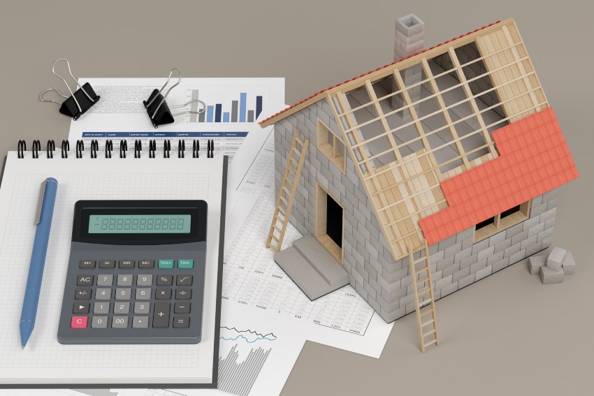A house model along a calculator representing roofing financing in Santa Cruz & Monterey Counties.